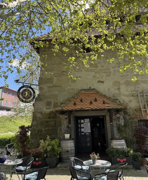 Vhod v Vodni stolp s teraso, sodi in cvetjem ob reki Dravi
