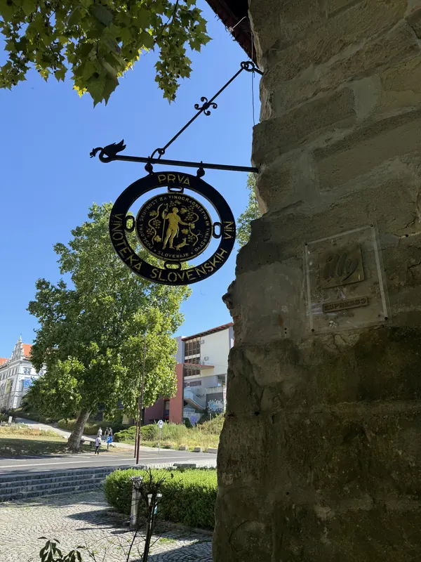 Kovana tabla Prve vinoteke slovenskih vin na fasadi Vodnega stolpa v Mariboru